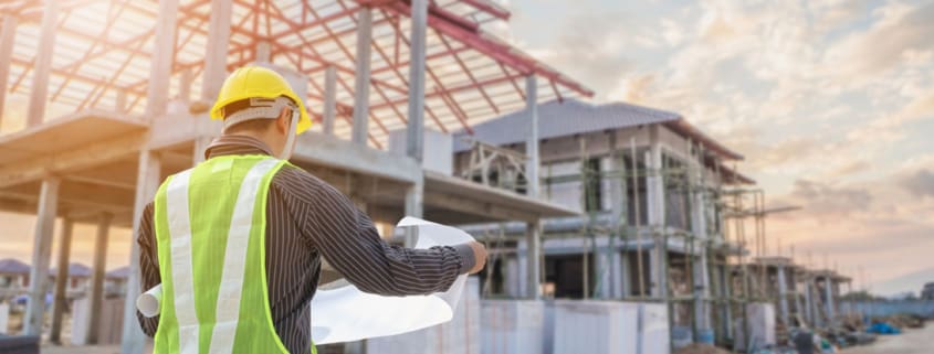 a man wearing a hard hat and holding a blueprint